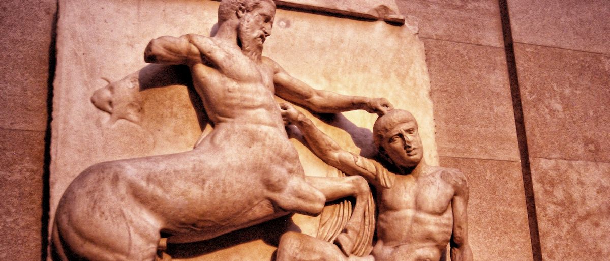 Parthenon North Frieze XXIX Centaur pushing naked man down, man is hitting back upwards with his right fist as he kneels under lifted front hoofs. Coloured reddish.