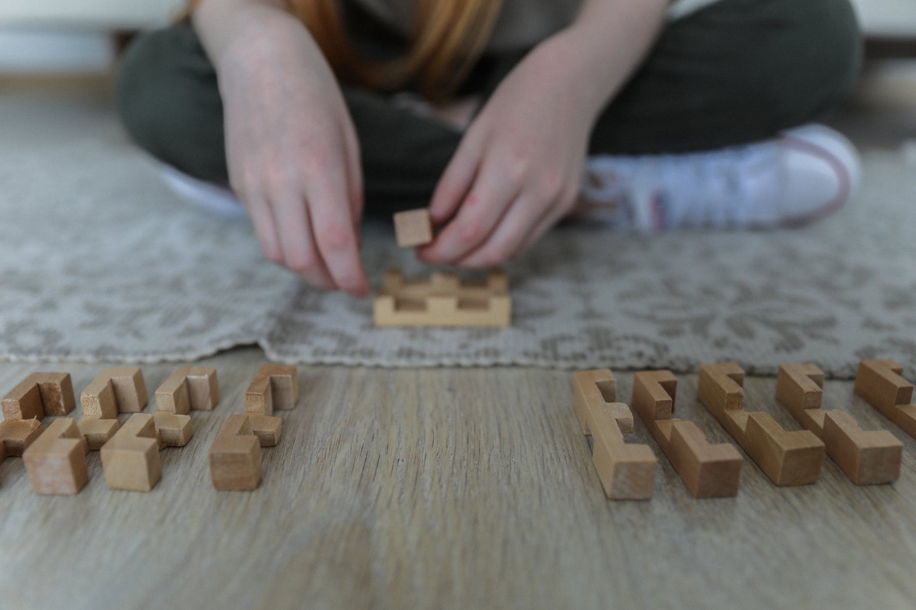 crop girl playing blocks on carpet